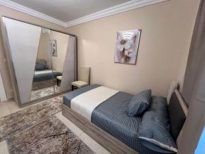 um quarto com uma cama e um espelho grande em Luxurious VIP apartment in Madinaty furnished with high end hotel furniture em Madinaty