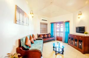 un soggiorno con divano e tavolo di 'Golden Sand Dunes' 1bhk Benaulim beach apartment a Madgaon