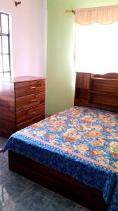 a bedroom with a bed and a dresser at 2 bedrooms house with furnished terrace and wifi at Fond du Sac 5 km away from the beach in Fond du Sac