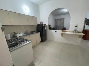 uma cozinha com um fogão e um frigorífico preto em Casa Medellin em Medellín