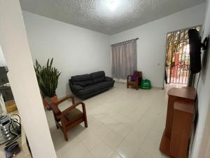 uma sala de estar com um sofá e uma cadeira em Casa Medellin em Medellín
