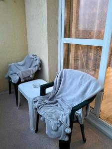 a room with two chairs and a table and a window at Füred Apartman in Balatonfüred