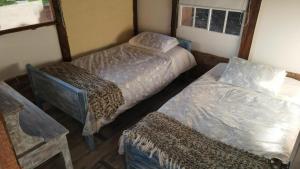 a room with two twin beds and a table at Cabaña Yerbabuena in Toca