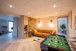 uma sala de estar com um sofá e uma mesa de bilhar em Le Terrier Ovifat - Appartement entier Familial - Sauna & Massage em Ovifat