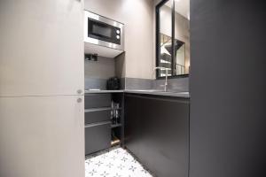 a kitchen with a sink and a microwave at Cosy home - Moulin rouge in Paris