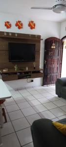 a living room with a flat screen tv on a wall at Casa Praia Indaia in Caraguatatuba