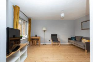 a living room with a couch and a tv at Newly Refurbished 2BD Flat wParking - Peckham! in London