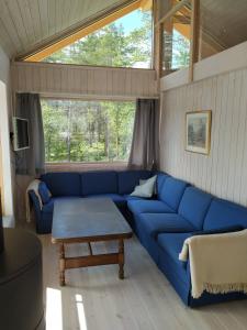 a living room with a blue couch and a table at Hytte ved Tunhovdfjorden in Tunhovd