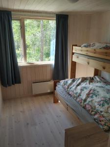 a bedroom with two bunk beds and a window at Hytte ved Tunhovdfjorden in Tunhovd