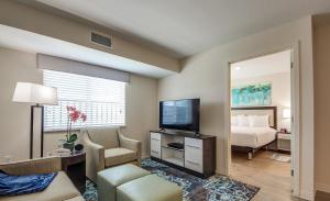 um quarto de hotel com uma cama e uma televisão em Parks Residential-Richardson em Richardson