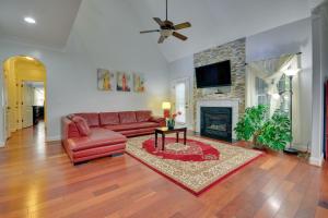 a living room with a red leather couch and a fireplace at High Point Vacation Rental with Private Deck! in High Point