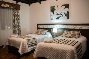- une chambre avec 2 lits et un tableau mural dans l'établissement Chuquiragua Lodge & Spa, à Machachi