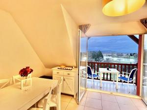a dining room with a view of a balcony at D36 2ème étage La Ferme de Deauville 1 ch. SOZEN C in Saint-Arnoult