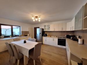 een keuken met een tafel en een keuken met witte kasten bij TREND in Arad