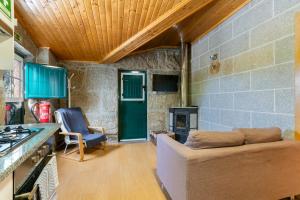 a living room with a couch and a fireplace at Casa Rústica T2 com Salamandra e Cozinha - Seia - Serra da Estrela - Casa do Loureiro II in Seia