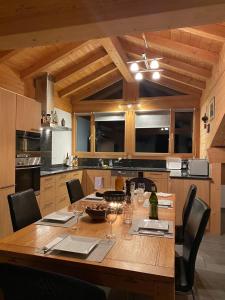 uma cozinha com uma mesa de madeira com copos de vinho em Attic in the Alps em Luzein