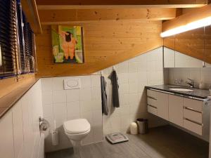 un bagno con un water e un lavandino di Attic in the Alps a Luzein Altre 13 foto