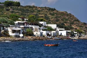 a boat in the water in front of a group of houses at Casa Le Due Sicilie in Panarea