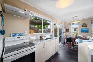 a kitchen with a sink and a large window at Kinder Cottage - Taupo in Taupo