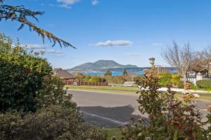 een lege straat met uitzicht op de oceaan en de bergen bij Kinder Cottage - Taupo in Taupo