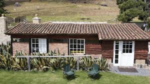 a small house with chairs in front of it at Cabaña Yerbabuena in Toca