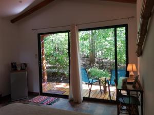 Zimmer mit einer Glasschiebetür zur Terrasse in der Unterkunft Baliyana Lodge in San José Pinilla