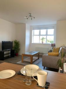 sala de estar con mesa y sofá en Central 2-Bed Flat: Ideal for Nurses, Contractors, Relocators - Free WiFi & Parking, en Peterborough