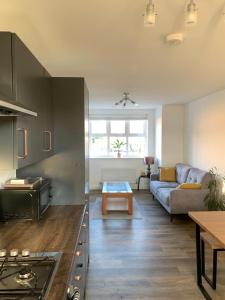 cocina y sala de estar con sofá y mesa en Central 2-Bed Flat: Ideal for Nurses, Contractors, Relocators - Free WiFi & Parking, en Peterborough