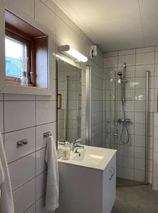 a bathroom with a sink and a shower at Charming Rorbu Stamsund Lofoten in Stamsund