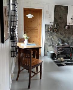 a kitchen with a table and a chair and a stove at Charming Rorbu Stamsund Lofoten in Stamsund