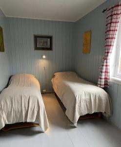 a bedroom with two beds and a window at Charming Rorbu Stamsund Lofoten in Stamsund