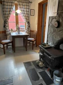a living room with a table and a fireplace at Charming Rorbu Stamsund Lofoten in Stamsund