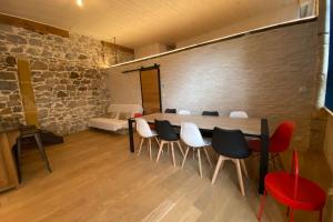a room with a table and chairs and a stone wall at Le Rivet charmant 12 personnes Terreaux in Lyon