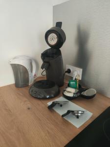 een aanrecht met een koffiezetapparaat en een klok erop bij Bienvenue à la plage ! in Argelès-sur-Mer