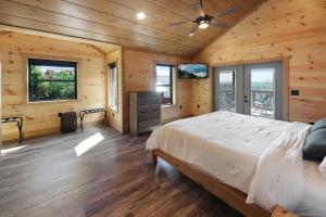 1 dormitorio con 1 cama en una habitación con paredes de madera en Big Bear Shack - Handicap Accessible & Dog Friendly, en Gatlinburg