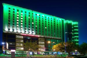 un edificio con luces verdes por la noche en Mercure Tyumen Center, en Tyumen
