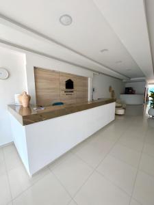 a white lobby with a reception desk in a building at Hotel AguaMarina Rodadero Santa Marta in Gaira