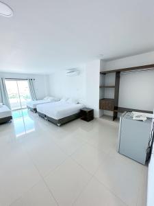 a white room with two beds and a chalkboard at Hotel AguaMarina Rodadero Santa Marta in Gaira