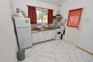 kuchnia z białymi urządzeniami i marmurową podłogą w obiekcie Kaiken Maison w mieście Villa Santa Cruz del Lago