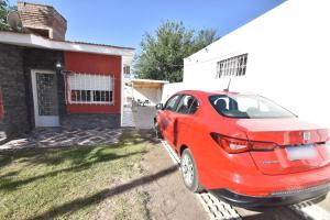 a red car parked in front of a house at Kaiken Maison in Villa Santa Cruz del Lago