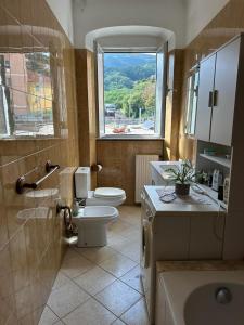 a bathroom with a toilet and a sink and a window at alchiccodoro in Genoa