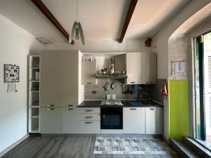 a kitchen with white cabinets and green accents at alchiccodoro in Genoa