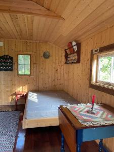 a room with a bed and a table in a cabin at koselig liten hytte i Skien in Skien