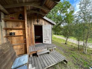 a wooden out house with a door and a porch at koselig liten hytte i Skien in Skien