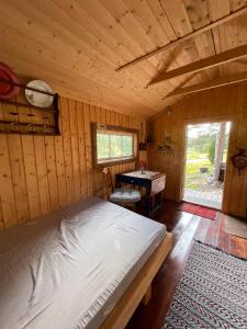 a bedroom with a bed and a table in a cabin at koselig liten hytte i Skien in Skien