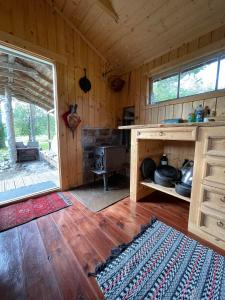 a wooden cabin with a stove and a wooden floor at koselig liten hytte i Skien in Skien