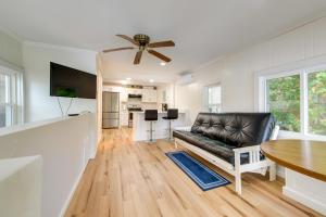 sala de estar con sofá de cuero negro y mesa en Horseshoe Lake Vacation Rental with Deck and Kayaks!, en Batavia