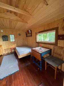 a room with a bed and a table in a cabin at koselig liten hytte i Skien in Skien