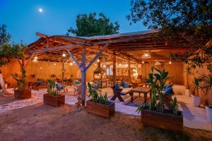 a wooden pavilion with chairs and tables in a yard at GÜLER BUTİK HOTEL in Antalya