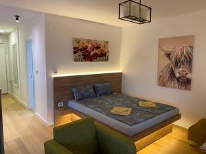 1 dormitorio con 1 cama con una vaca en la pared en Vrtovi Ceraka en Belgrado
